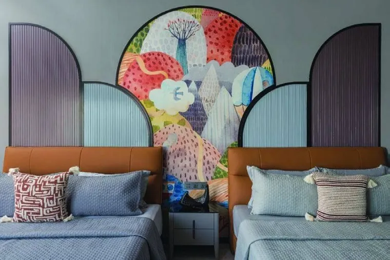 Twin bedroom with arched panels and a hand-painted mural headboard wall