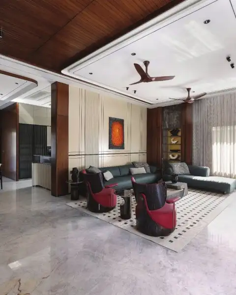 Double-height living room with walnut ceiling, grey sofas and red accent chairs