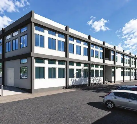 Two-storey hospital building with continuous ribbon windows and parking in front