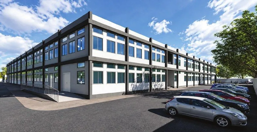 Two-storey hospital building with continuous ribbon windows and parking in front
