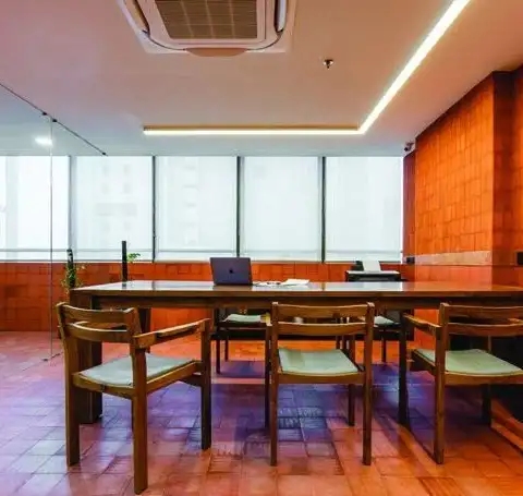 Conference room with terracotta tile wall, timber table and linear lighting